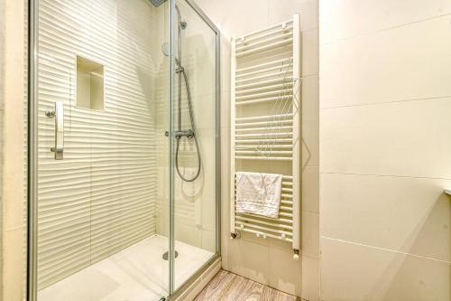 une douche avec une porte vitrée dans une salle de bain dans l'établissement 44 Foch 3, à Grenoble