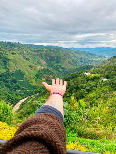 a person with their hand up on a mountain at Hotel Kasama in San Agustín