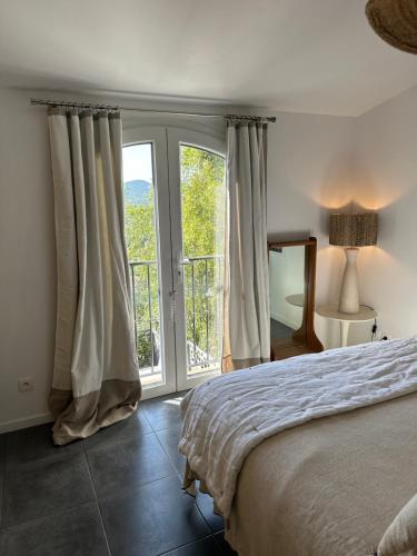 une chambre avec un lit et une grande fenêtre dans l'établissement mazet proche de st Tropez, à Cogolin