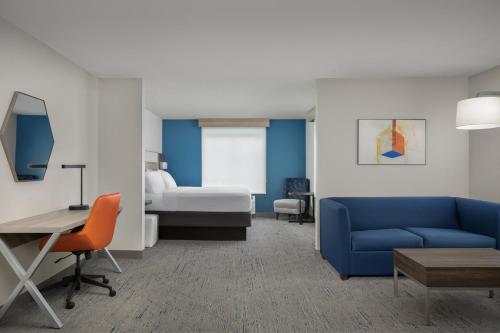 a living room with a blue couch and a bed at Holiday Inn Express & Suites Superior by IHG in Superior