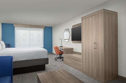 a bedroom with a bed and a desk with a television at Holiday Inn Express & Suites Superior by IHG in Superior