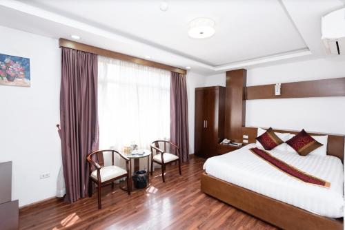 Habitación de hotel con cama, mesa y sillas en Khách sạn Rococo, en Hanói
