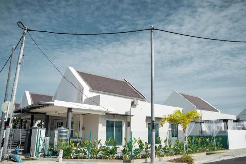 uma casa branca com um telhado cinzento em Hayyan cozy place em Kuala Kedah