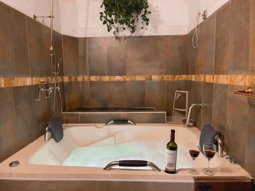 a bath tub with a bottle of wine and two glasses at Casa Real Barichara in Barichara