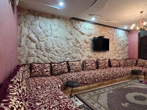 un sofá en una habitación con una pared de piedra en "Pearl in Middle Atlas", en Azrou