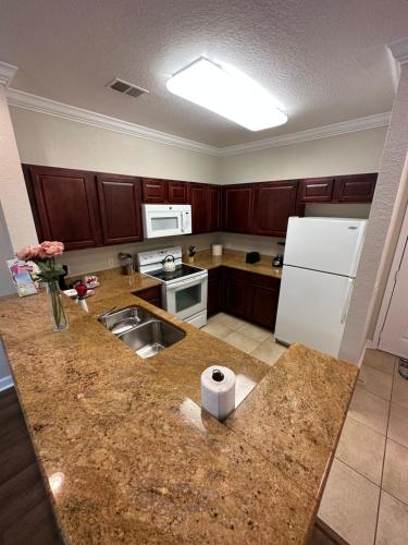 a kitchen with a counter with a sink and a refrigerator at Gone 2 Florida Vacation Homes in Orlando