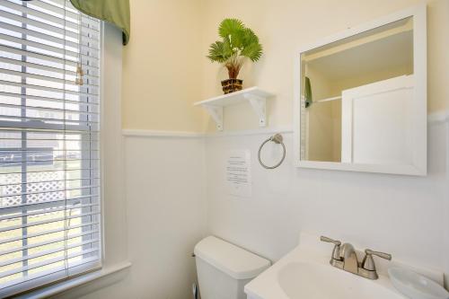 a bathroom with a toilet and a sink and a mirror at Cozy Jersey Shore Cottage with Beach Chairs! in Wildwood