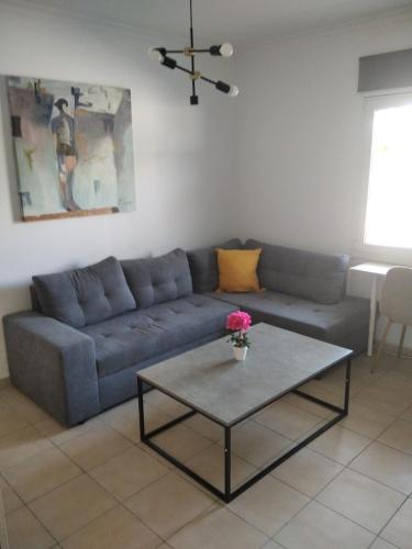 ein Wohnzimmer mit einem Sofa und einem Tisch in der Unterkunft Glyfada First Center in Athen