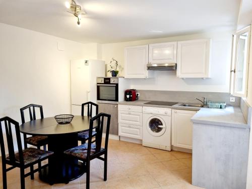 a kitchen with a table and chairs and a kitchen with white cabinets at Ma Douce in Grasse