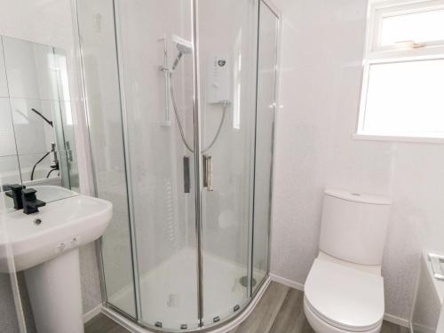 a bathroom with a shower and a toilet and a sink at 10 Southcliffe Drive in Filey