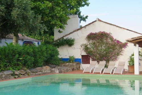 a group of chairs sitting next to a swimming pool at Herdade da Madalena in Sousel