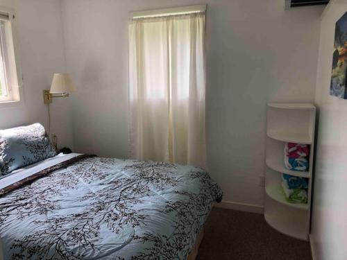 a bedroom with a bed and a window at Cozy Lakefront with Beach of your own! in Franklin