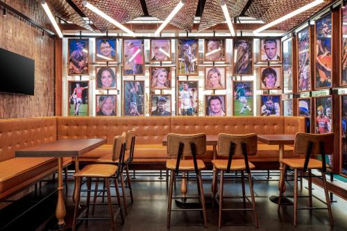 a restaurant with tables and chairs in front of a wall of pictures at Holiday Inn & Suites - Dubai Science Park by IHG in Dubai