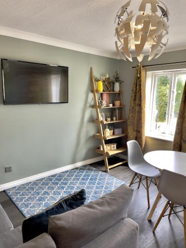 een woonkamer met een bank, een tafel en een kroonluchter bij Monkbridge Mews Apartment in York