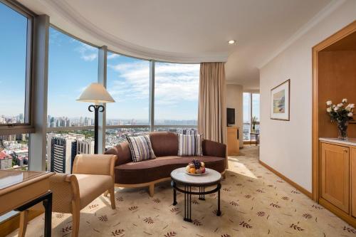 a living room with a couch and a table at Sheraton Nanjing Kingsley Hotel & Towers in Nanjing
