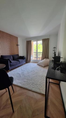 uma sala de estar com um sofá azul e uma mesa em Cosy Studio near Monaco SEA VIEW Balcony em Beausoleil