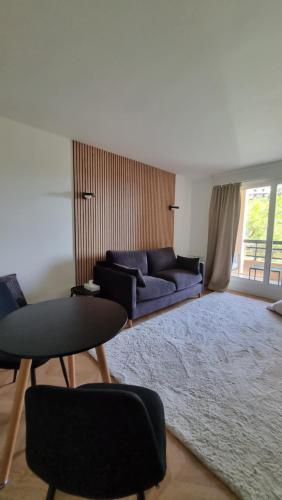 uma sala de estar com um sofá azul e um tapete em Cosy Studio near Monaco SEA VIEW Balcony em Beausoleil