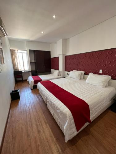 a large bedroom with two beds and a red headboard at Hotel Florencia Plaza in Medellín