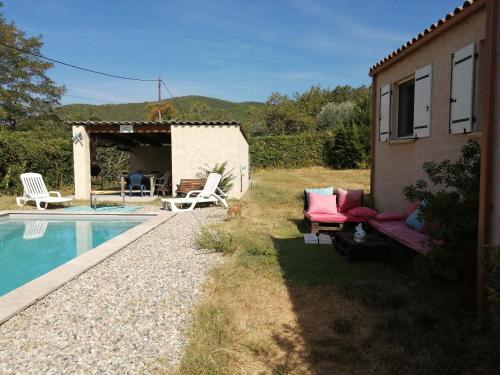 a house with a swimming pool next to a building at The happy house in Le Martinet