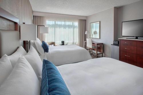 a hotel room with two beds and a flat screen tv at Marriott Philadelphia West in West Conshohocken
