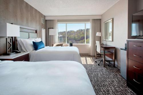 a hotel room with two beds and a desk and a window at Marriott Philadelphia West in West Conshohocken