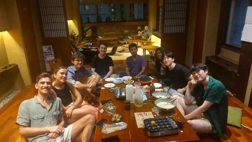 a group of people sitting around a table at Guest House Tokyo Samurai in Tokyo