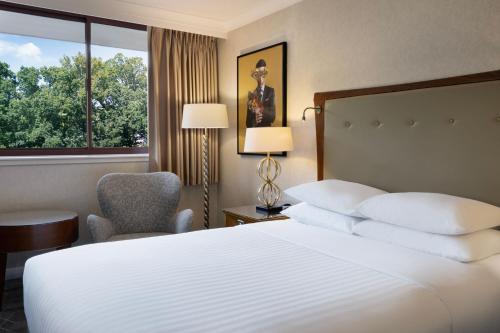 a hotel room with a bed and a chair and a window at Delta Hotels by Marriott Swindon in Swindon