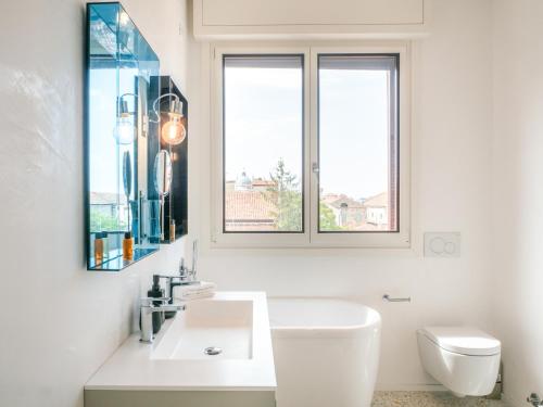 uma casa de banho branca com um lavatório e um WC em Le Terrazze em Veneza