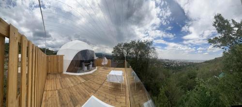 uma casa num deque de madeira com uma tenda branca em Panorama Almaty em Almaty