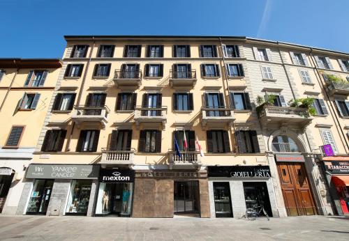 a large building on a city street with stores at Hotel Fenice in Milan