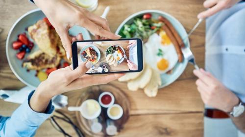 two people taking a picture of a table with food at InterContinental Al Khobar by IHG in Al Khobar