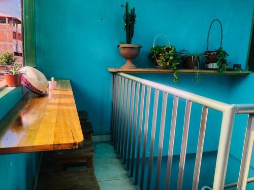 Habitación azul con mesa de madera y macetas en Habitación simple, en Urubamba