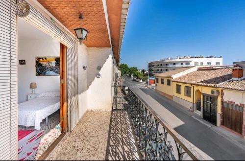 a balcony with a bed and a view of a street at La Solariega in Padul
