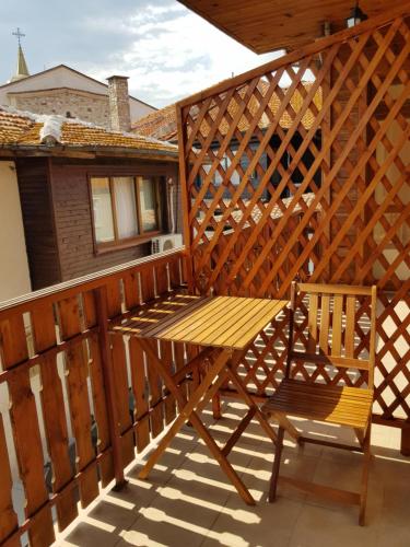 a wooden deck with a bench and a wooden fence at Villa Nikoli in Nesebar