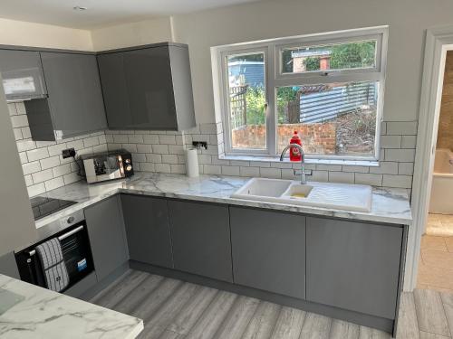 uma cozinha com um lavatório e uma janela em 3 bedroom house Maidstone em Maidstone