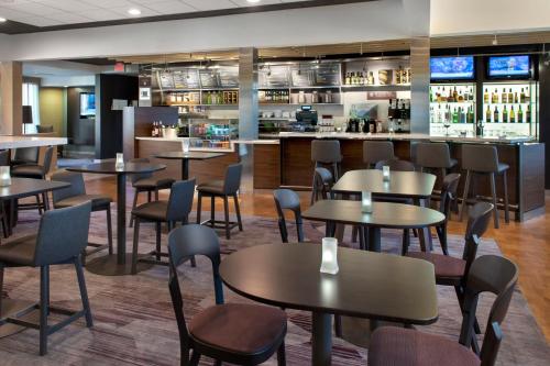 a restaurant with tables and chairs and a bar at Courtyard by Marriott Mt. Laurel in Mount Laurel