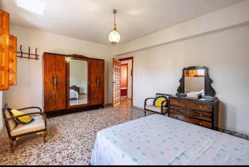 a bedroom with a bed and a dresser and a mirror at La Solariega in Padul