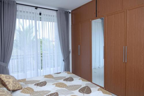 1 dormitorio con cama y ventana grande en LAYENSA, en Gampaha