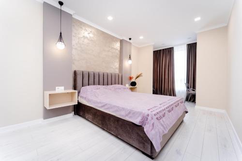 a bedroom with a bed with a pink bedspread at 2-Bedroom Family Grandeur Apartment in Chişinău