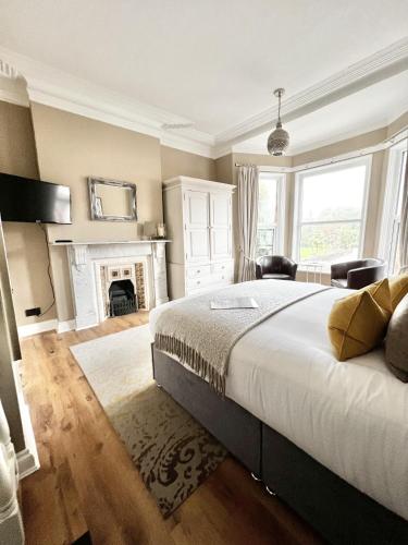 1 dormitorio con 1 cama grande y chimenea en Devon House Guest House, en Paignton