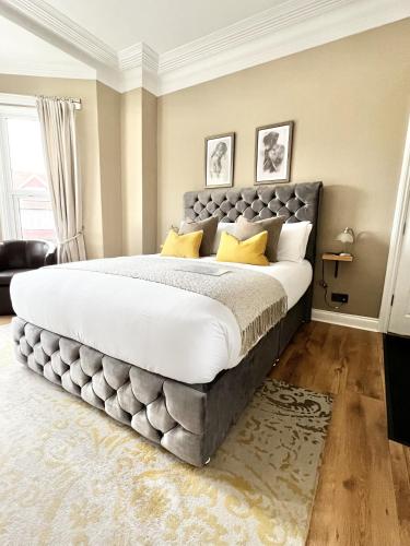 a large bedroom with a large bed with yellow pillows at Devon House Guest House in Paignton
