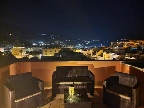 two chairs and a table on a balcony at night at Residence Alberghiero Eolie in Lipari