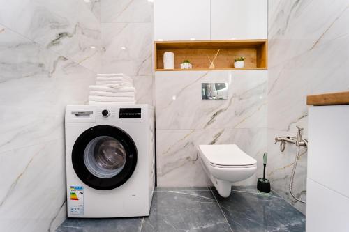 a bathroom with a washing machine and a toilet at 2-Bedroom Family Grandeur Apartment in Chişinău