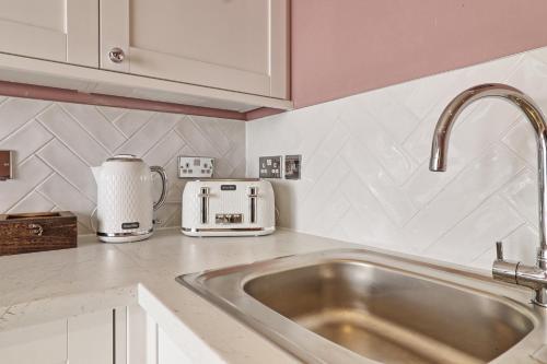 a kitchen counter with a sink and a toaster at Plush Nest - Charming One-Bedroom Flat - Southend Stays in Southend-on-Sea