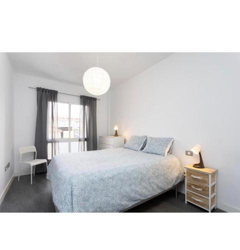 1 dormitorio con cama, lámpara y silla en COCO apartament. en El Médano