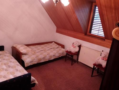 a attic room with two beds and two chairs at Smeštaj Milekić - Nova Varoš in Vraneša