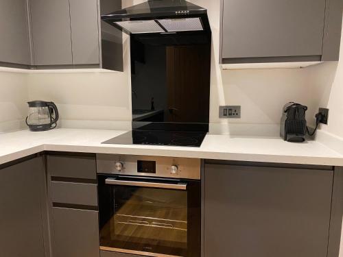 uma cozinha com uma placa de fogão e forno. em Steisean a dha with office - Comet apartments em Helensburgh