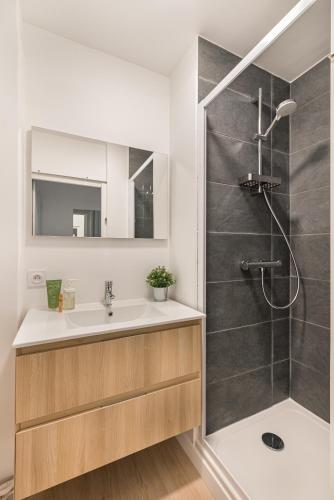 une salle de bain avec un lavabo et une douche dans l'établissement APPART COSY - COMME À LA MAISON - ST ETIENNE, à Saint-Étienne