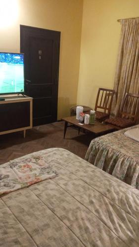 a hotel room with two beds and a television at lodecampu in Asuncion