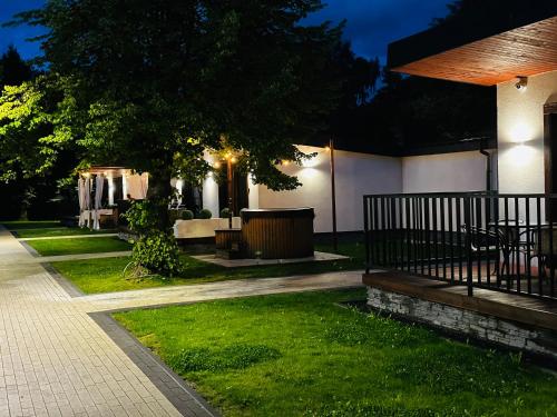 a backyard at night with a table and a fence at WRZOS resort & wellness **** DOMKI CAŁOROCZNE in Węgierska Górka